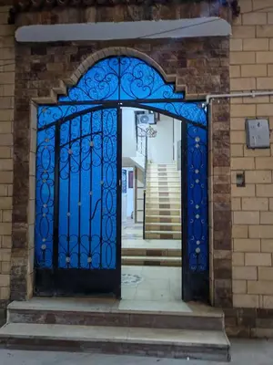 an entrance to a building with a blue gate at El faraón egipcio apartment in Al Karnak