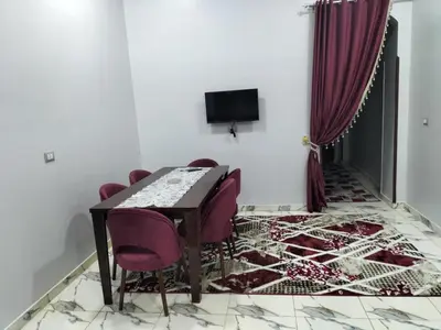 a dining room with a table and purple chairs at El faraón egipcio apartment in Al Karnak