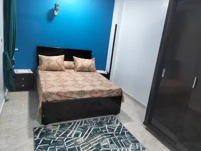a bedroom with a bed with a blue wall at El faraón egipcio apartment in Al Karnak