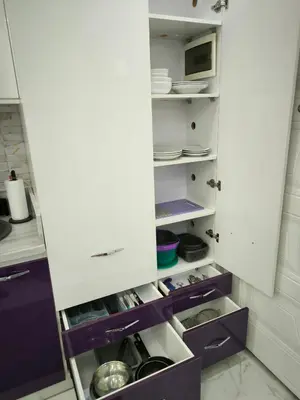 an open refrigerator with purple drawers and dishes at Hurghada Chill Out Home in Hurghada