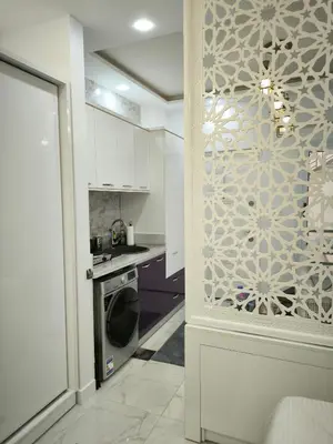 a kitchen with white cabinets and a washer and dryer at Hurghada Chill Out Home in Hurghada