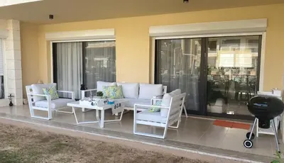 a patio with a couch and chairs and a table at Modern 3BR Poolside Apt at Cribs El Gouna in Hurghada