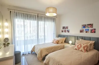 a bedroom with two beds and a large window at Modern 3BR Poolside Apt at Cribs El Gouna in Hurghada