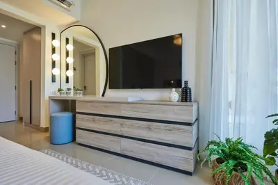 a bedroom with a large dresser with a large mirror at Modern 3BR Poolside Apt at Cribs El Gouna in Hurghada