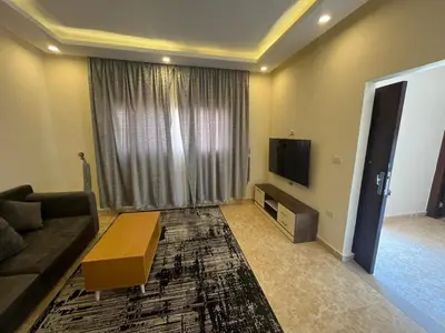 a living room with a couch and a tv at Mirage Bay Aqua Park Apartments in Hurghada