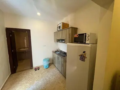 a small kitchen with a refrigerator and a microwave at Mirage Bay Aqua Park Apartments in Hurghada