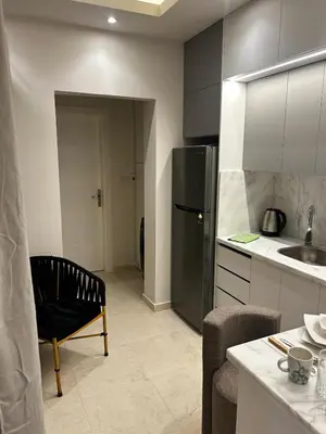 a kitchen with a refrigerator and a chair in it at Luxury Apartment in Hurghada