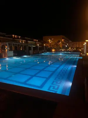 a large swimming pool lit up at night at Luxury Apartment in Hurghada