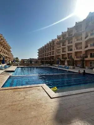 a large swimming pool in front of a large building at Luxury Apartment in Hurghada