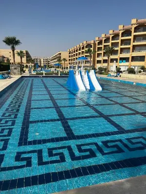 a swimming pool with a slide in front of a building at Luxury Apartment in Hurghada