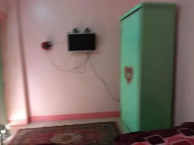 a bedroom with a green cabinet and a tv on the wall at هاي موود in Jazīrat Aswān
