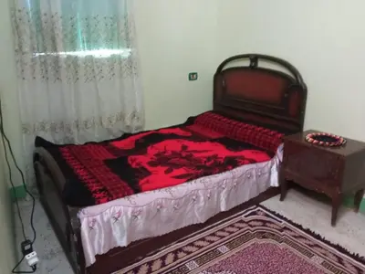 a bedroom with a large bed and a table at هاي موود in Jazīrat Aswān