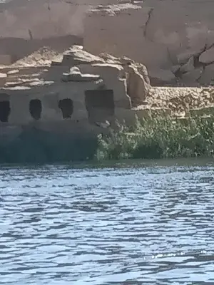 an old building next to a body of water at Felucca Alaska in Aswan