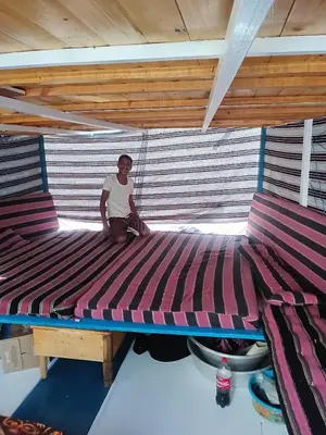 a man sitting on a large bed in a room at Felucca Alaska in Aswan