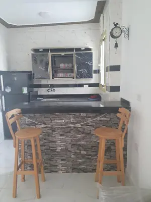 a kitchen with two wooden stools and a counter at Apartment sea view in Hurghada