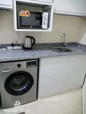 a kitchen with a microwave and a washing machine at La quinta hights in Hurghada