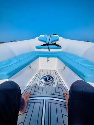 a person sitting on a bed with their feet on the floor at Wave Dancer in Hurghada