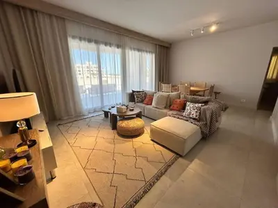 a living room with a couch and a table at Fanadir Marina 2BR GF • Stunning View in Hurghada
