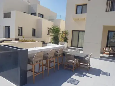a patio with a bar with chairs and a table at Fanadir Marina 2BR GF • Stunning View in Hurghada