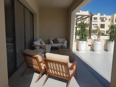 a balcony with two chairs and a couch at Fanadir Marina 2BR GF • Stunning View in Hurghada