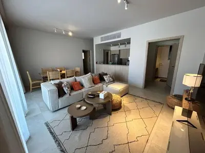 a living room with a couch and a table at Fanadir Marina 2BR GF • Stunning View in Hurghada