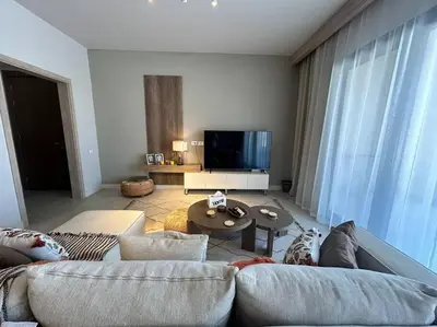 a living room with a couch and a tv at Fanadir Marina 2BR GF • Stunning View in Hurghada