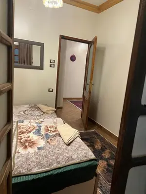 a bedroom with two beds and a door to a hallway at Aswan House center in Aswan