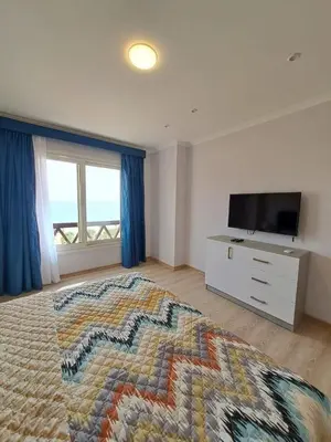 a bedroom with a large bed and a television at Tawaya Sea View 2 bedrooms in Hurghada