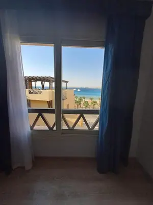 a room with a window with a view of the beach at Tawaya Sea View 2 bedrooms in Hurghada
