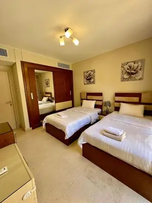 a hotel room with two beds and a bathroom at El-Gouna in Hurghada