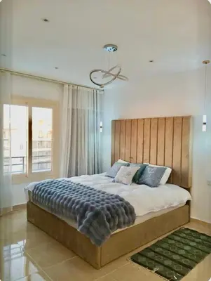 a bedroom with a large bed with a wooden headboard at Luxury Newly Built 2 DOUBLE bedroom and living room with Beach Access and Pool in Hurghada, Egypt in Hurghada