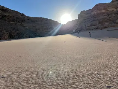two people walking on a sandy beach with the sun at Luxury Newly Built 2 DOUBLE bedroom and living room with Beach Access and Pool in Hurghada, Egypt in Hurghada