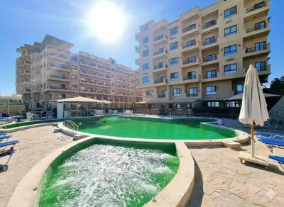 a swimming pool in front of a large building at Hurhgada concierge at Turtles beach resort in Hurghada