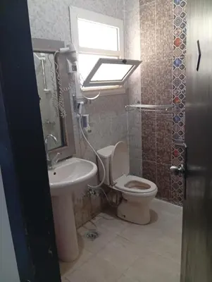 a bathroom with a toilet and a sink and a window at شقه للإيجار مكيفه in Hurghada
