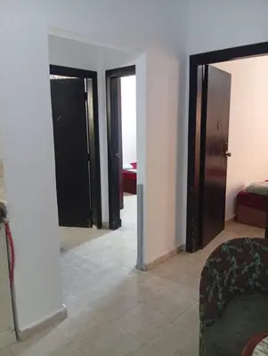 a living room with three doors and a couch at شقه للإيجار مكيفه in Hurghada