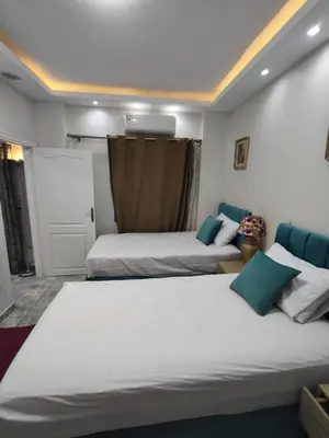 a bedroom with two beds and a door at Oasis Resort Compound in Hurghada