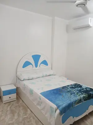 a bedroom with a bed with a blue and white mattress at Essa Apartment in Safaga