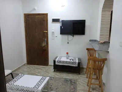a room with a door and a table and a chair at Essa Apartment in Safaga