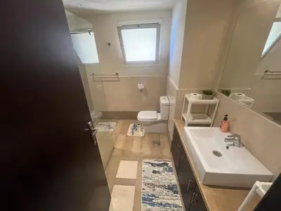 a bathroom with a sink and a toilet and a mirror at Azzurra Sea&pool View 2Bedrooms in Hurghada