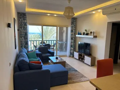 a living room with a blue couch and a tv at Azzurra Sea&pool View 2Bedrooms in Hurghada