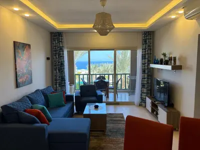 a living room with a blue couch and a tv at Azzurra Sea&pool View 2Bedrooms in Hurghada
