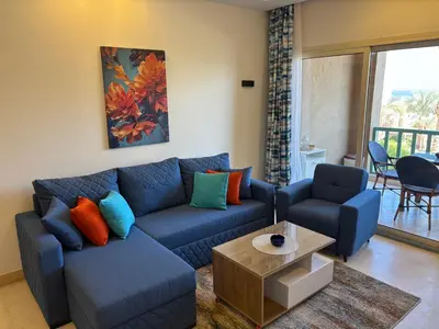 a living room with a blue couch and a table at Azzurra Sea&pool View 2Bedrooms in Hurghada