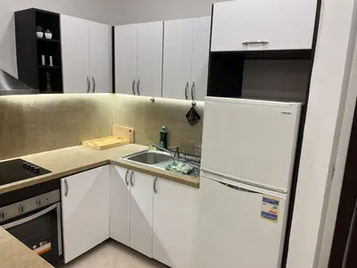 a kitchen with a white refrigerator and a sink at Azzurra Sea&pool View 2Bedrooms in Hurghada