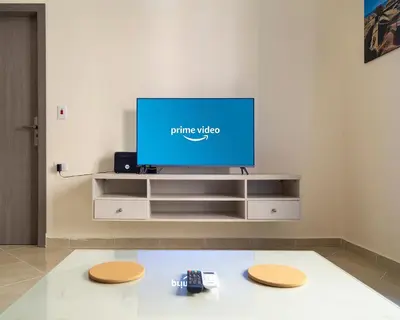 a tv in a living room with two remote controls at Bayt Hassan S2 - Cosy 1 bedroom apartment in Hurghada