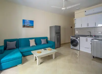 a living room with a blue couch and a table at Bayt Hassan S2 - Cosy 1 bedroom apartment in Hurghada