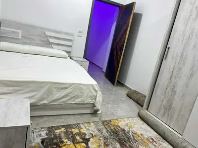 a bedroom with a bed and a purple door at Elegant Stay Apartment in Hurghada