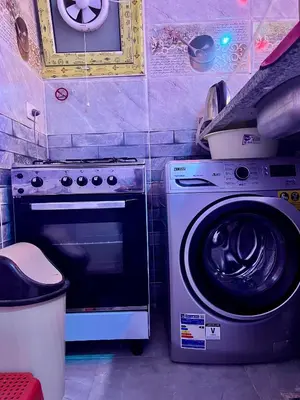 a kitchen with a stove and a washing machine at Elegant Stay Apartment in Hurghada