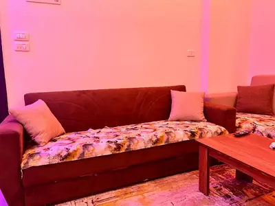 a couch sitting in a living room with a table at Elegant Stay Apartment in Hurghada