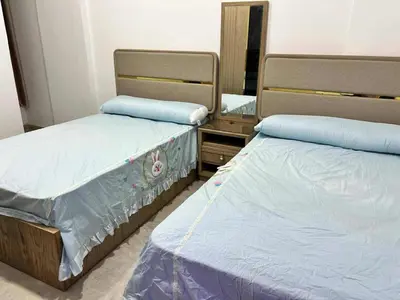 two beds sitting next to each other in a bedroom at Elegant Stay Apartment in Hurghada