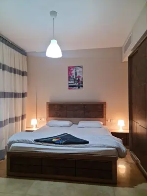 a bedroom with a large bed with a wooden headboard at 1 bedroom in mangroovy El gouna in Hurghada